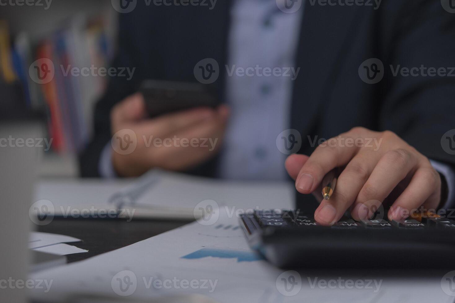 Businessman using calculator and accounting documents at desk with laptop computer. photo