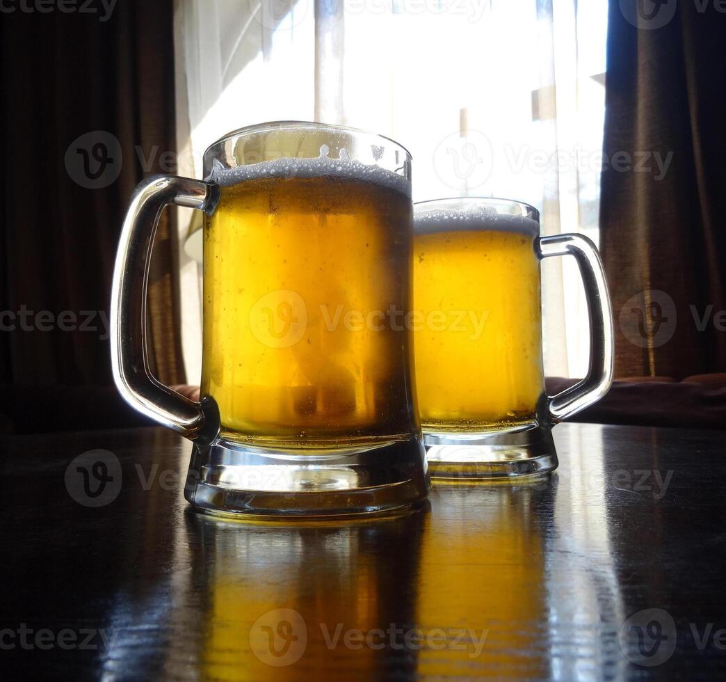 Full glasses of light beer on the wooden table at restaurant photo