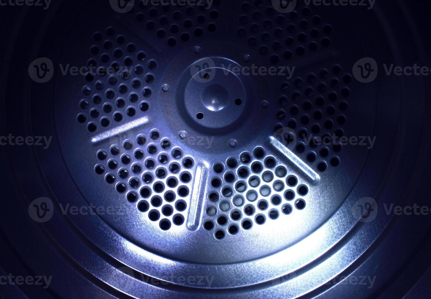 Fragment of a round metal plate with perforated holes texture background photo