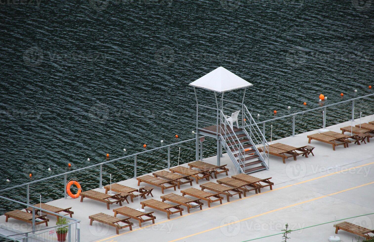 Lifeguard Stand Between Deckchairs At Relax Area Near Pond photo