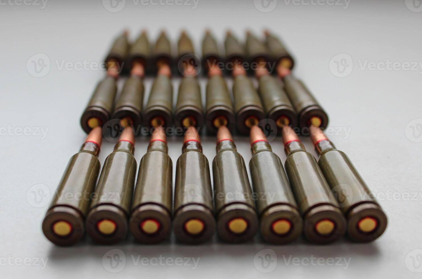 Closeup View Of live ammunition capsules for assault rifle laid out in rows on white background photo