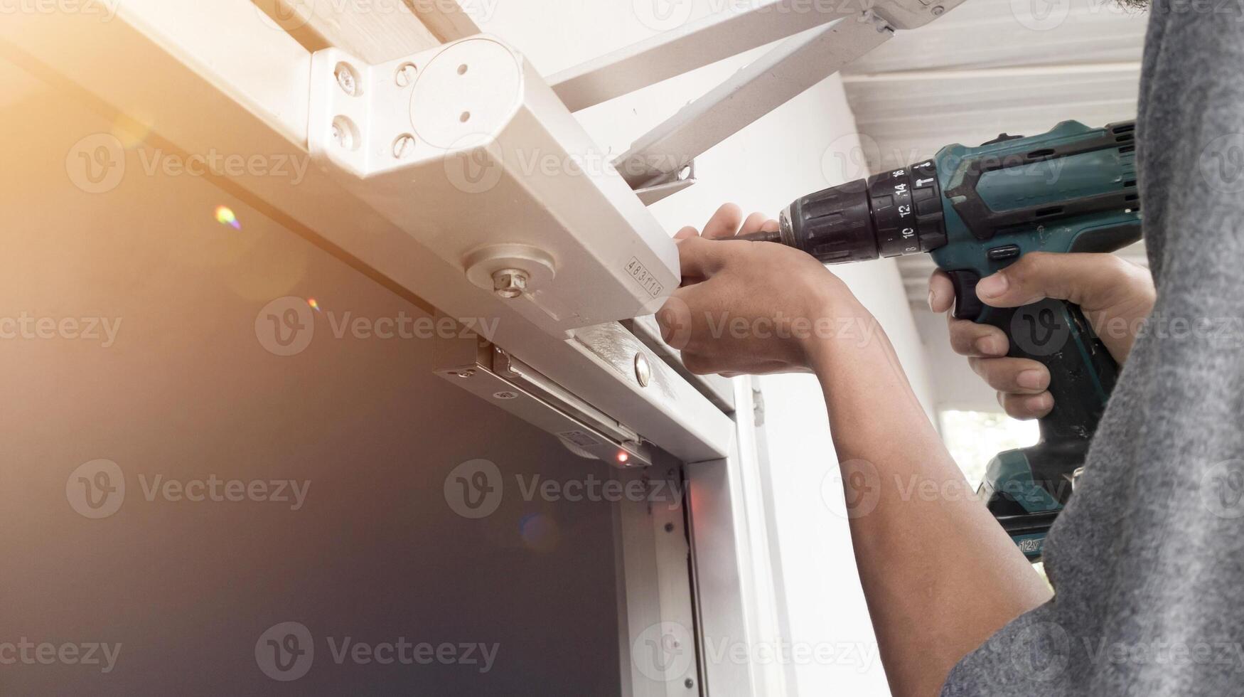 The man installing Magnetic lock system on the door for control of security system.And Installing automatic door closed with shiny light. photo