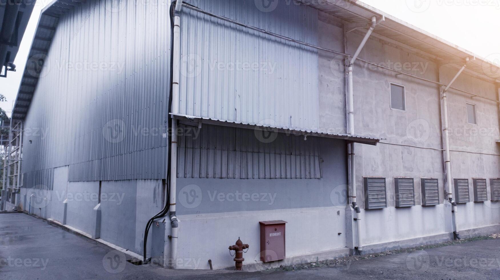 Industrial building with steel roof construction and  installed exhaust fans on the wall, and with hydrant installation. photo
