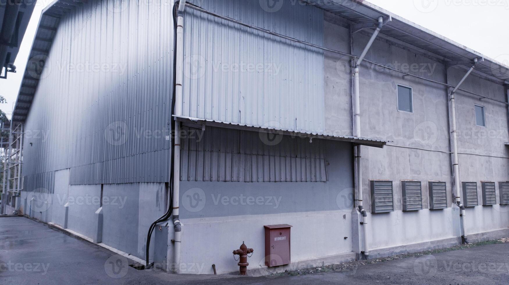 industrial edificio con acero techo construcción y instalado cansada aficionados en el muro, y con boca de aguas instalación. foto