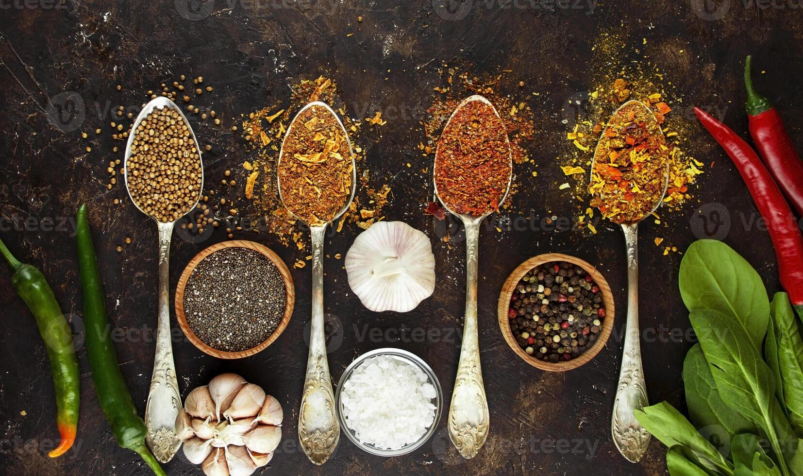 A variety of spices and herbs on a dark table. Cooking background. View from above. Ingredients for cooking. Table background menu. Copy space. photo