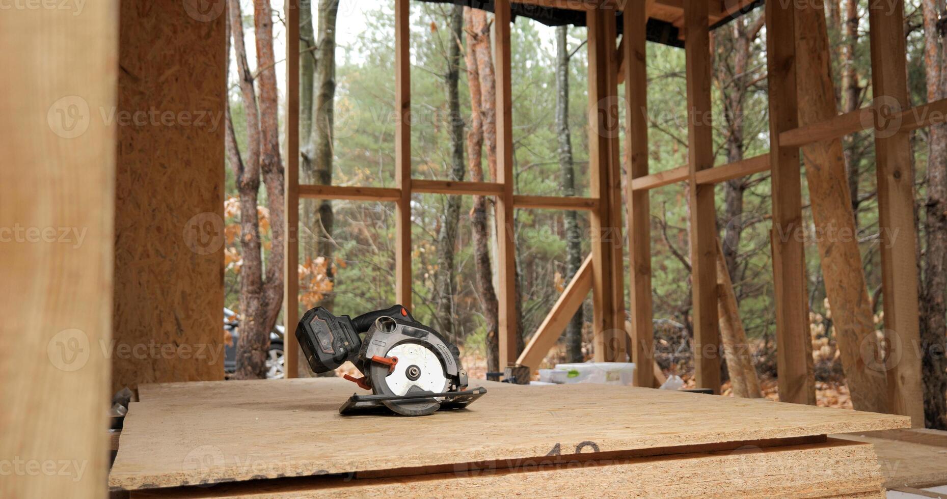 Circular saw in a wooden house under construction. Construction of a new wooden house using frame technology. Carpentry and construction concept. photo