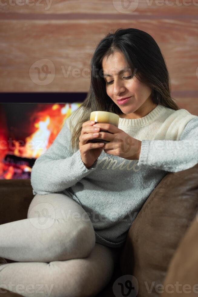 Woman enjoys a drink while relaxing at home. photo