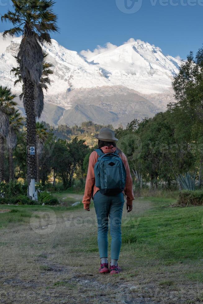 Tourist walks through the town named Yungay with the snow-capped Huascaran in the background. photo