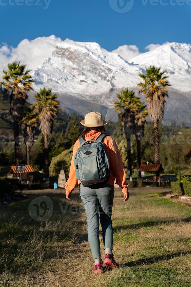 Tourist walks through the town named Yungay with the snow-capped Huascaran in the background. photo