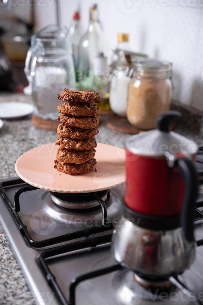 Freshly prepared cookies in the kitchen, served on a plate next to a coffee maker. photo