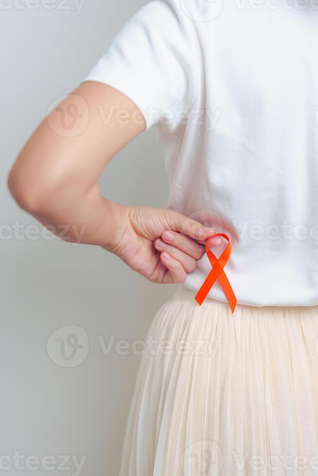 mujer teniendo espalda abdomen dolor con naranja cinta. riñón cáncer conciencia marzo mes, enfermedad de urinario sistema y piedras, cáncer, crónico riñón, urología, renal y trasplante concepto foto