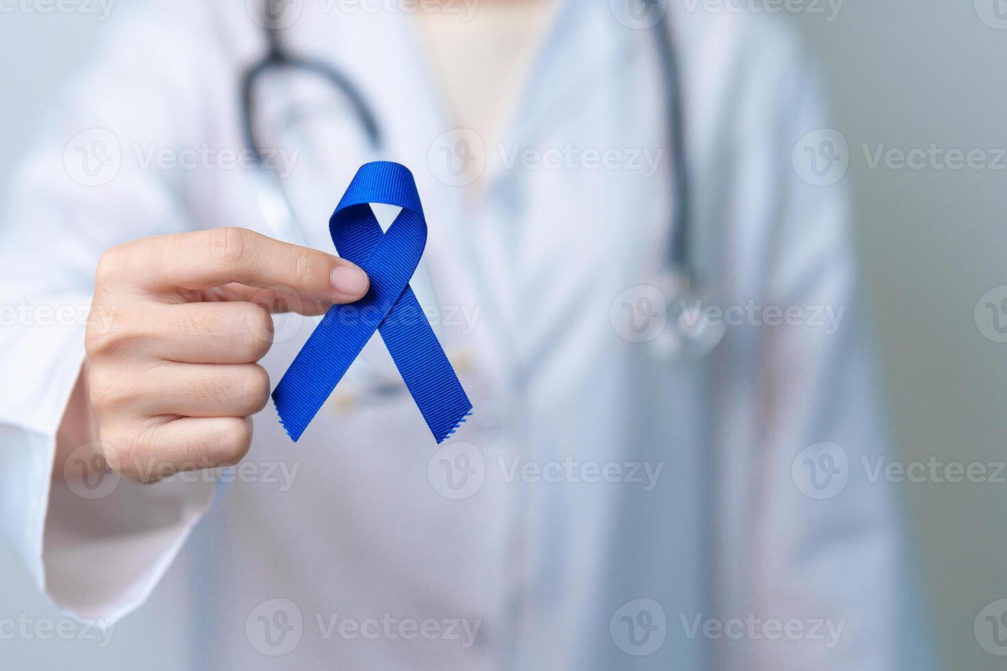 March Colorectal Cancer Awareness month, doctor with dark Blue Ribbon for supporting people living and illness. Healthcare, hope and World cancer day concept photo