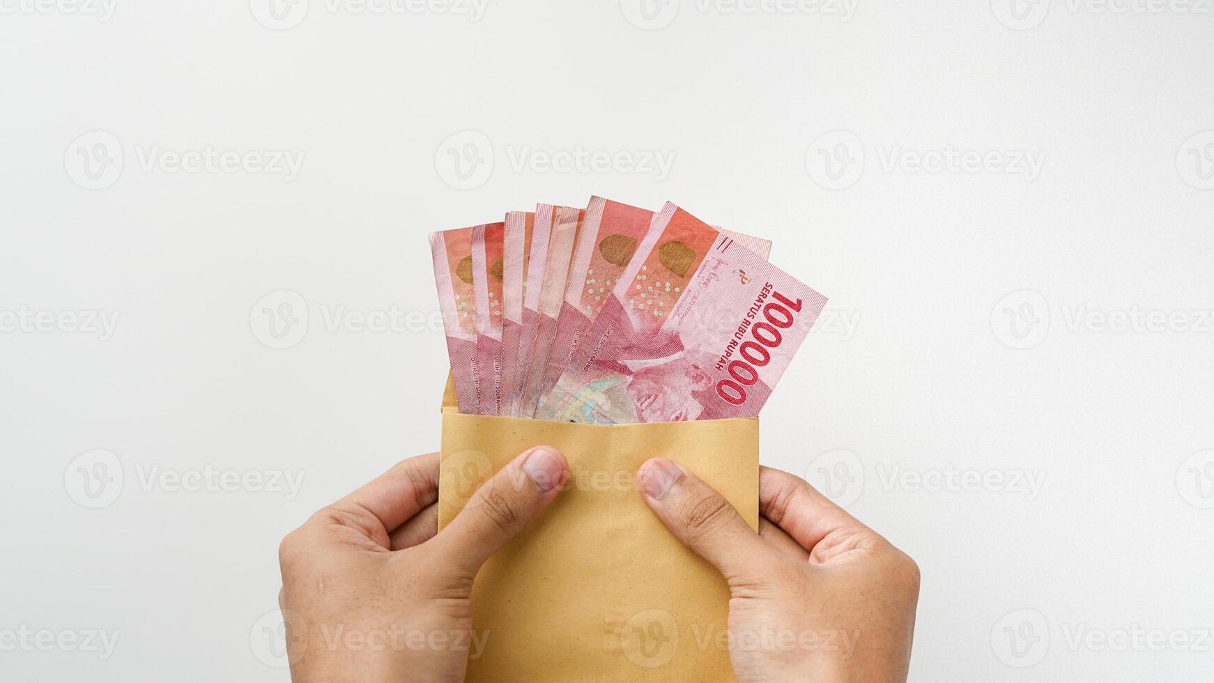 Hand holding rupiah money in a brown envelope. Indonesian currency photo