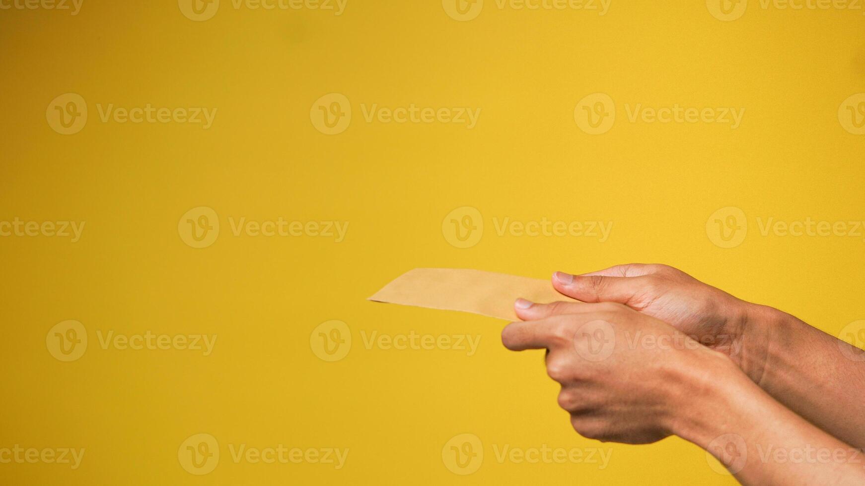 Man's hand gives money envelope isolated on pink background photo
