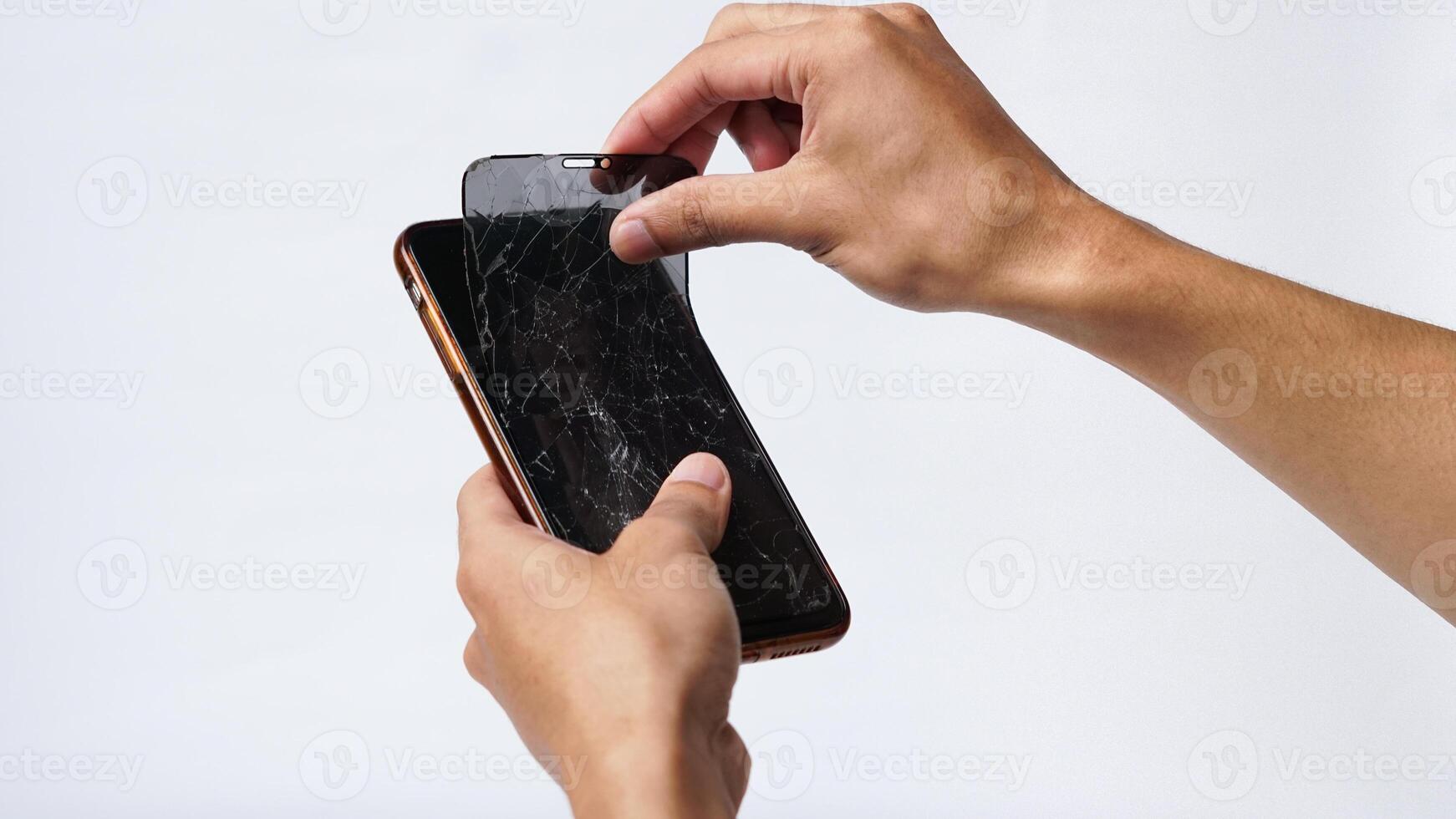 Man holding smartphone with broken touchscreen display on white background photo