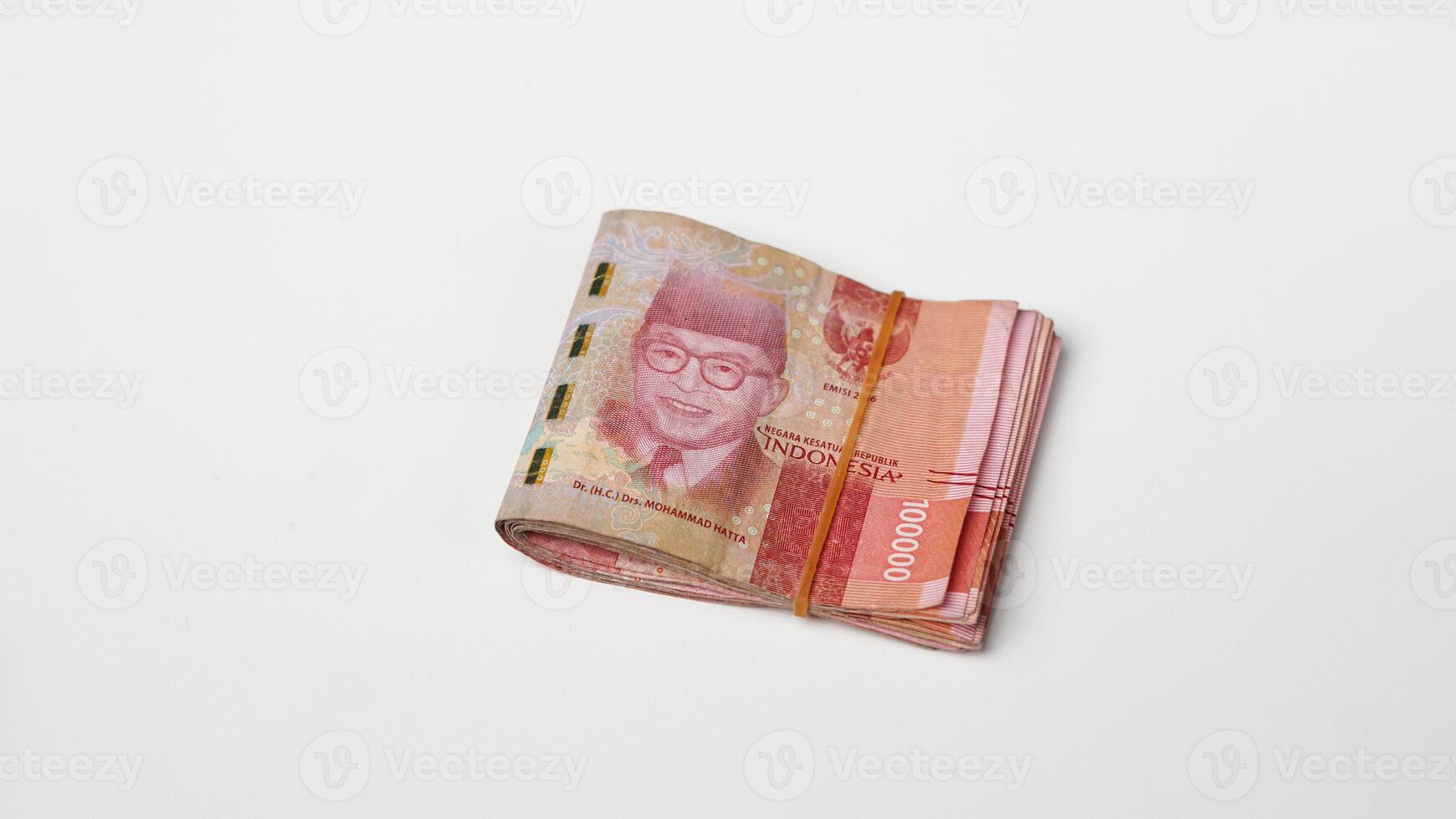 a wad of Indonesian rupiah banknotes tied with rubber photo
