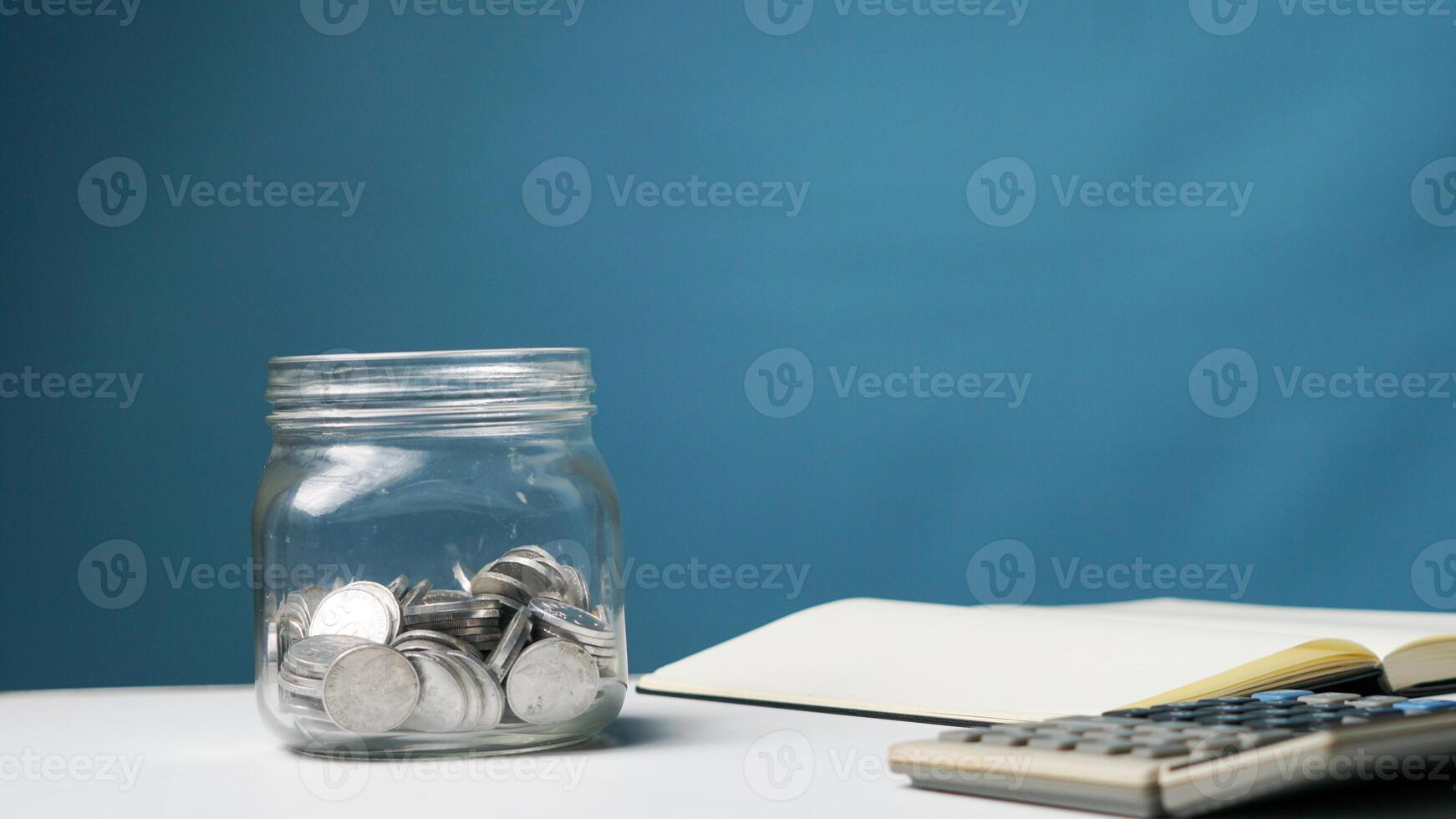 stack of coins in a clear transparent glass jar photo