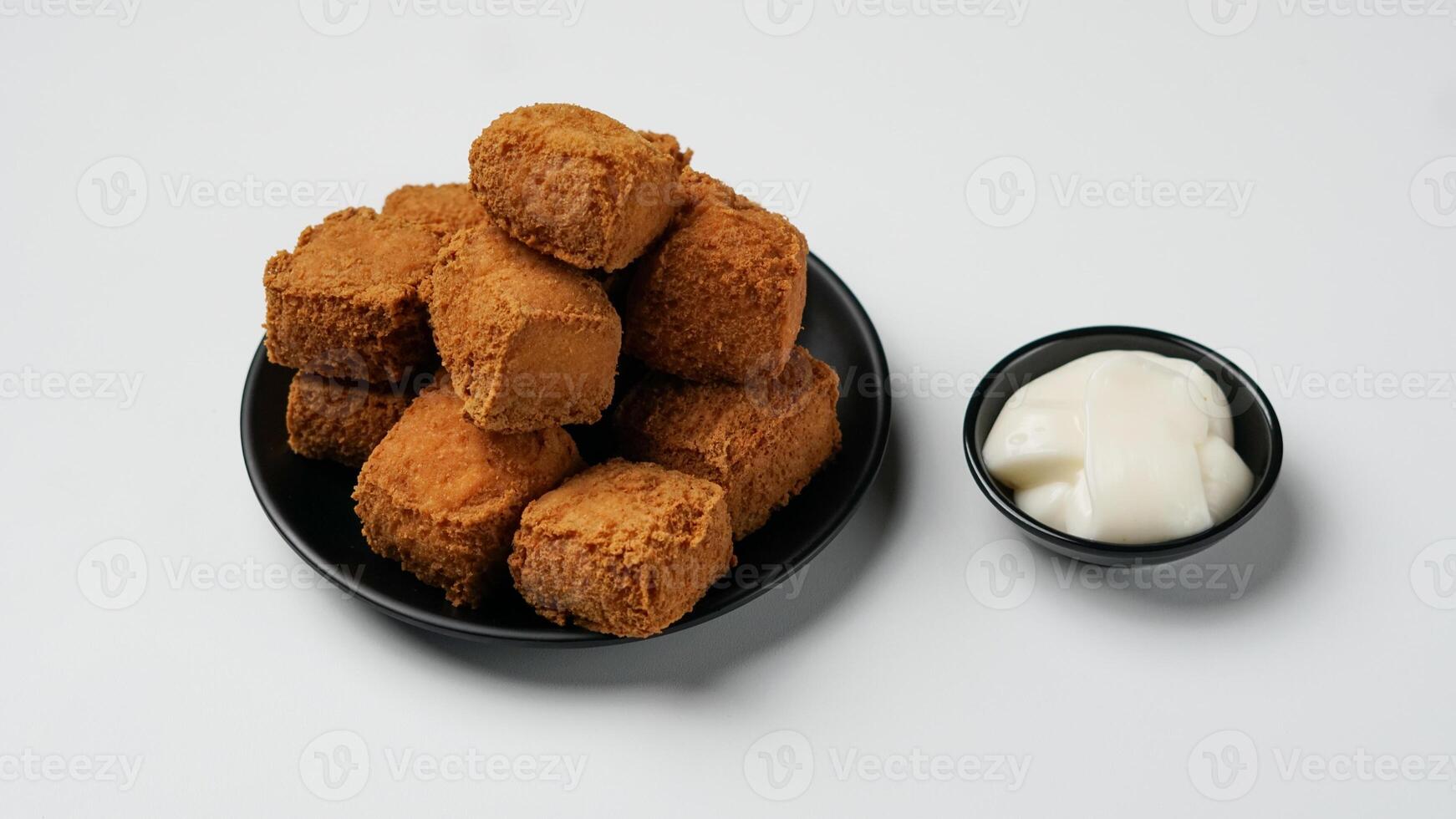 frito tofu en un negro plato con mayonesa en un blanco antecedentes foto