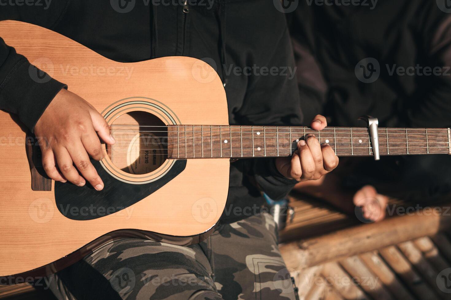 a visitor is playing guitar in a food stall. playing an acoustic guitar photo