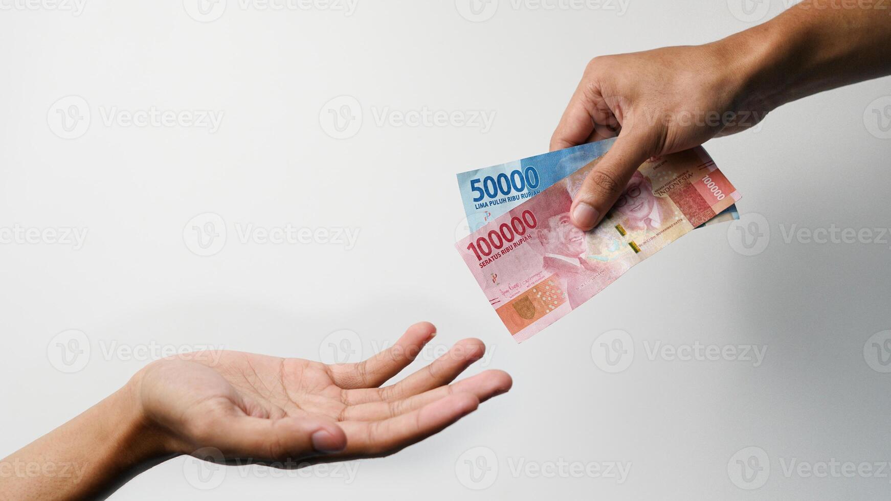 concept of hands giving and receiving Indonesian money. concept of sharing money for bribe photo