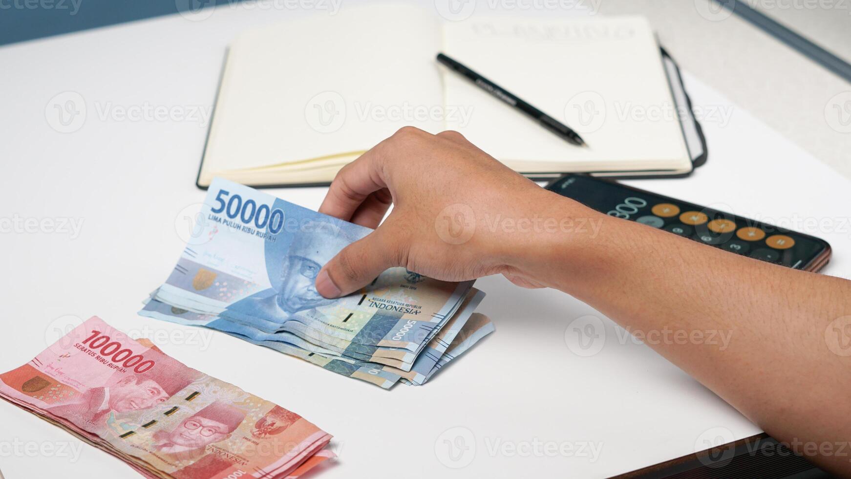 a man is counting Indonesian rupiah banknotes. financial management concept photo