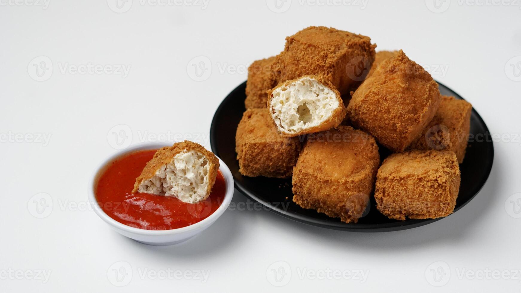 Fried tofu on a black plate with three sauces of mayonnaise, chili and sweet soy sauce on a white background photo