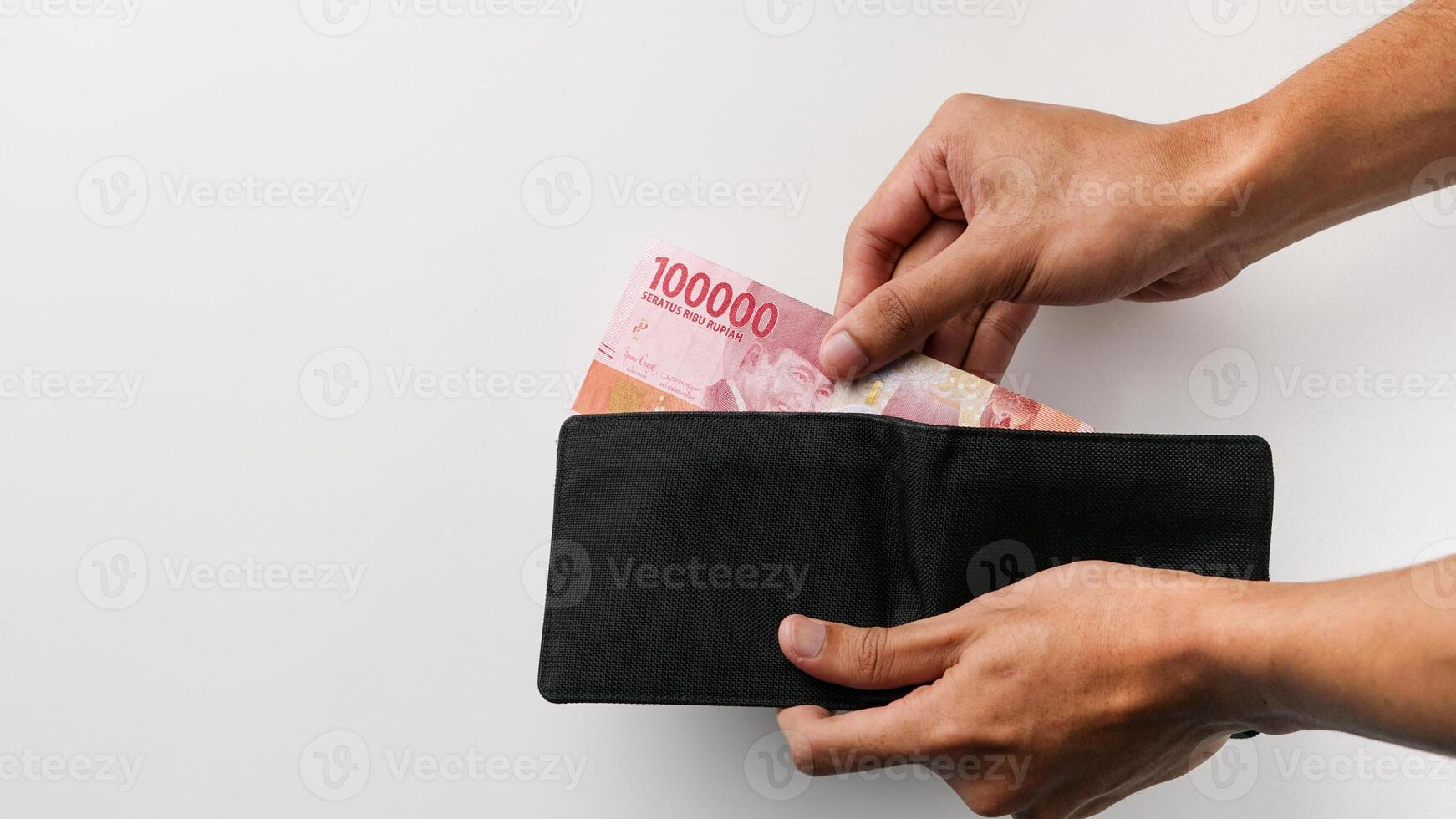 Hands taking out money 100.000 from wallet. the concept of paying and saving photo