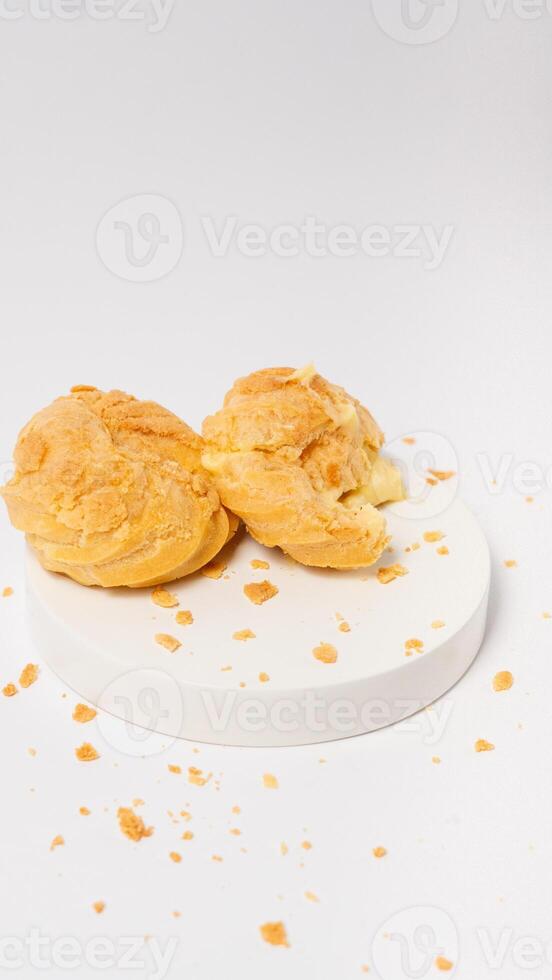 Freshly baked cream puffs or Vanilla eclairs isolated on white background photo