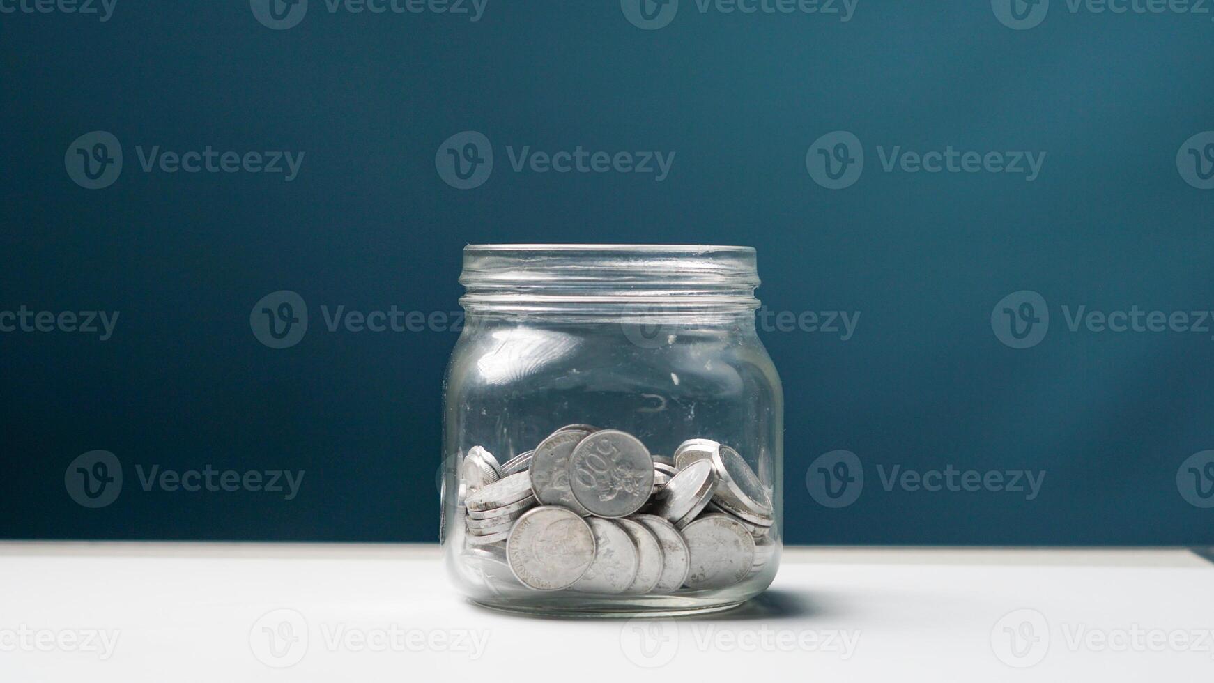 stack of coins in a clear transparent glass jar photo