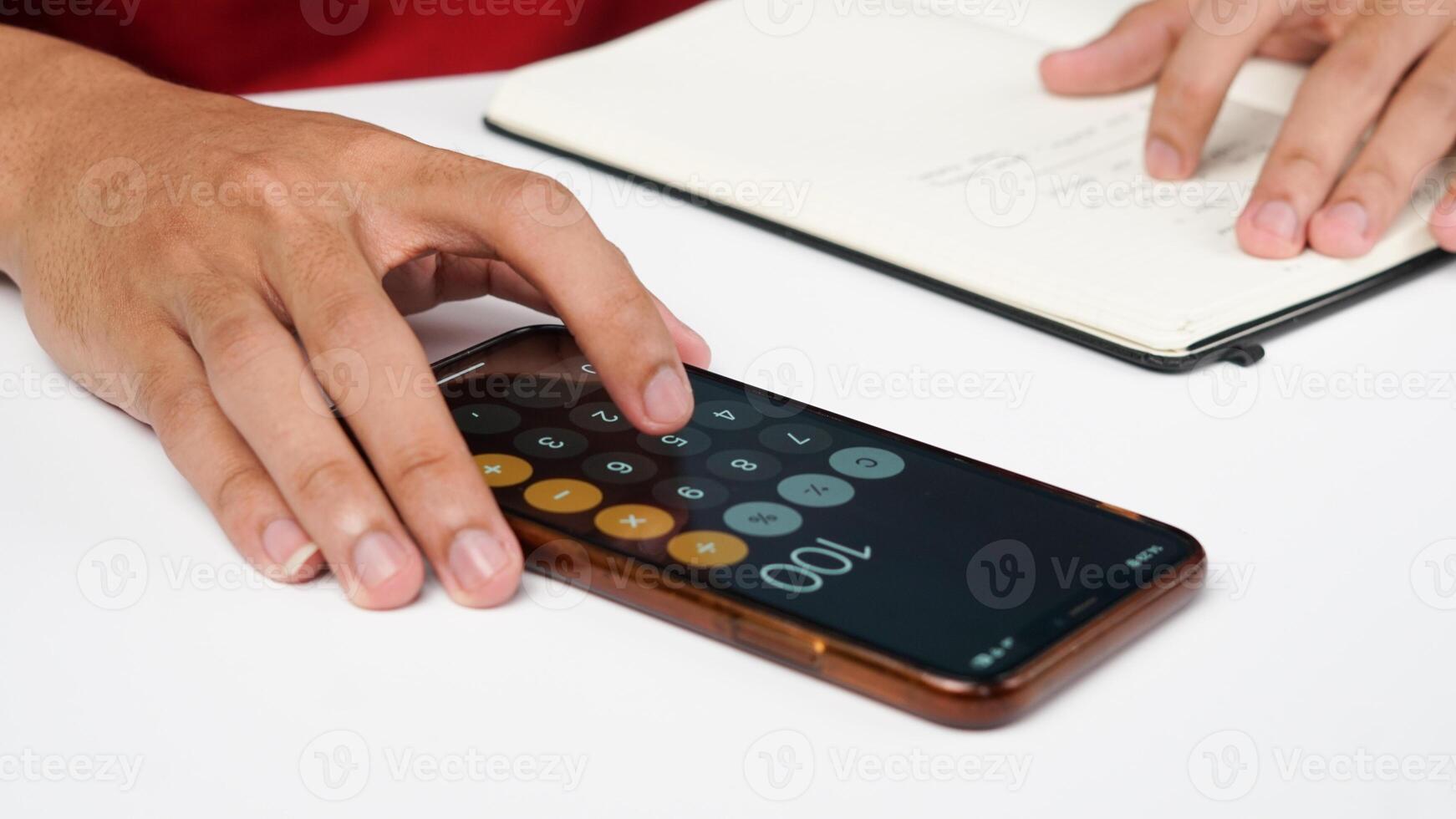hombre es tocando en teléfono inteligente calculadora y escritura notas foto