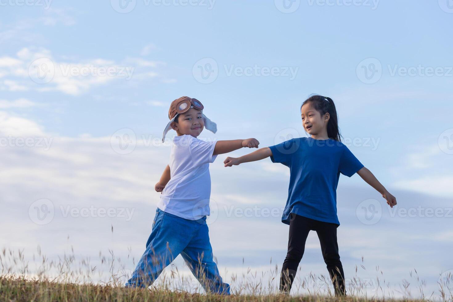 adorable niño chico y niña teniendo divertido exterior. pequeño niños jugar superhéroe, niños jugando al aire libre. asiático niños jugando foto