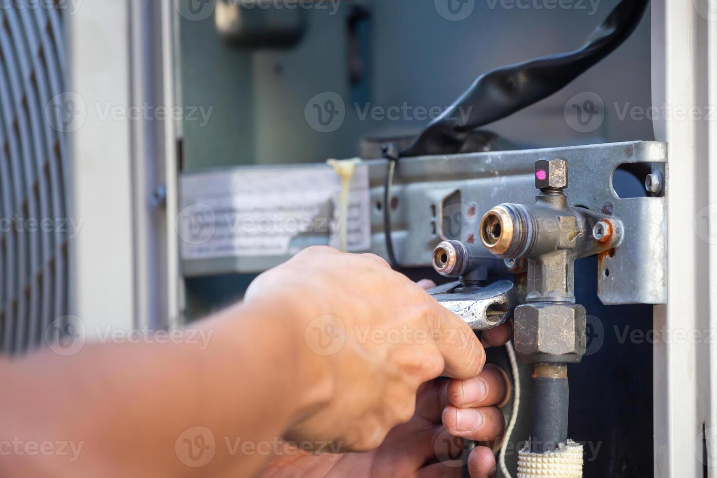 Close-up of Technician man using a wrench fixing modern air conditioning system, Air conditioning Maintenance and Repairing Concepts photo