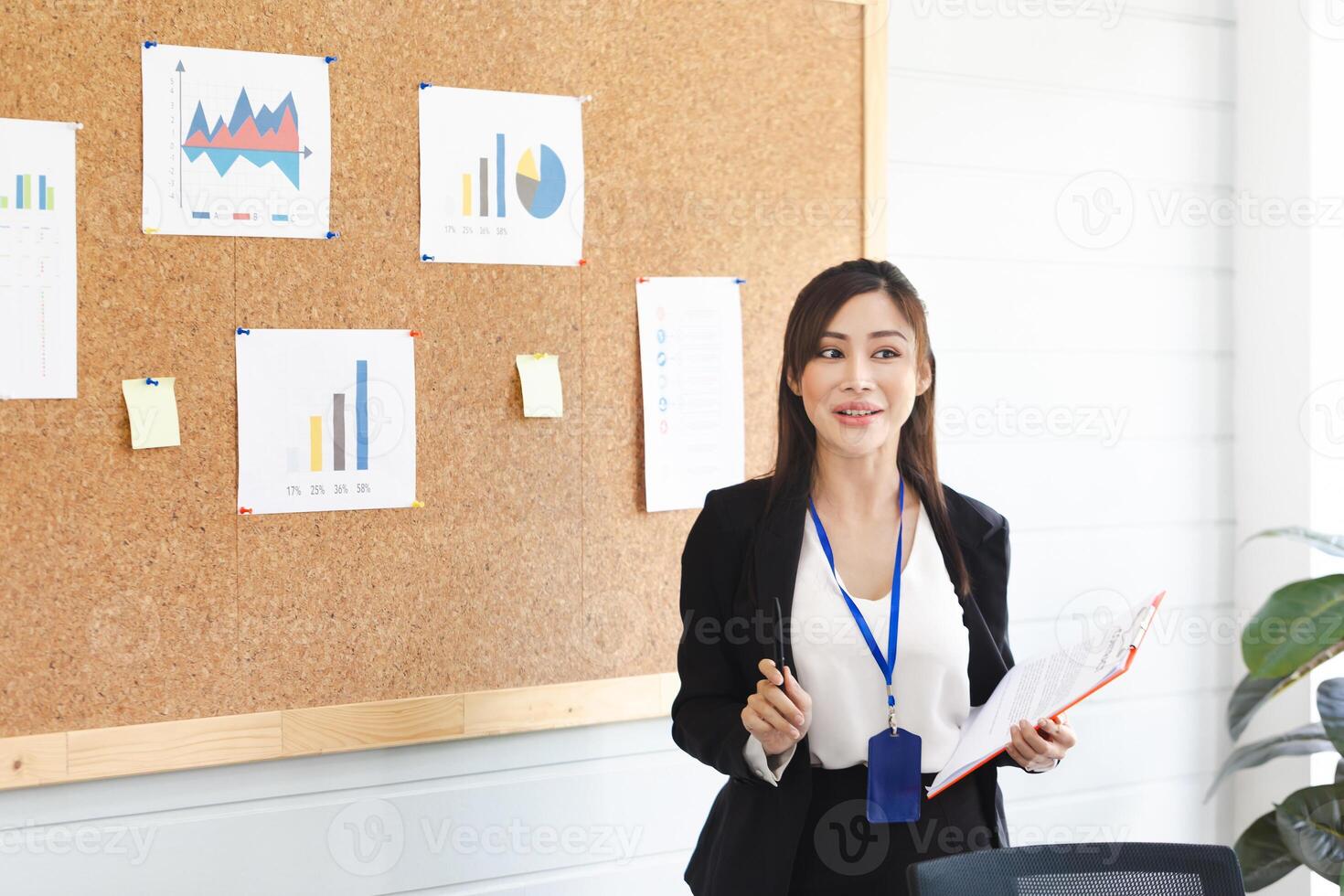 Asian woman making a presentation in front of board, Young female employee explains business data on board in the office meeting room photo