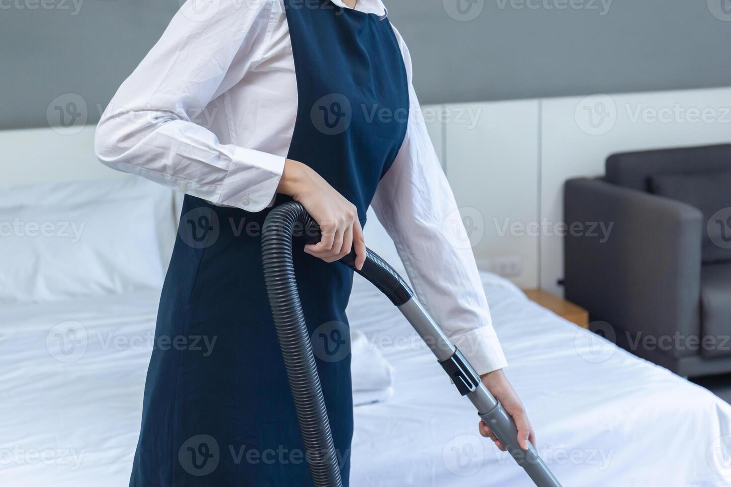 Room service maid cleaning a hotel room, chambermaid making bed in hotel room, Female housekeeper putting clean towels on bed. photo