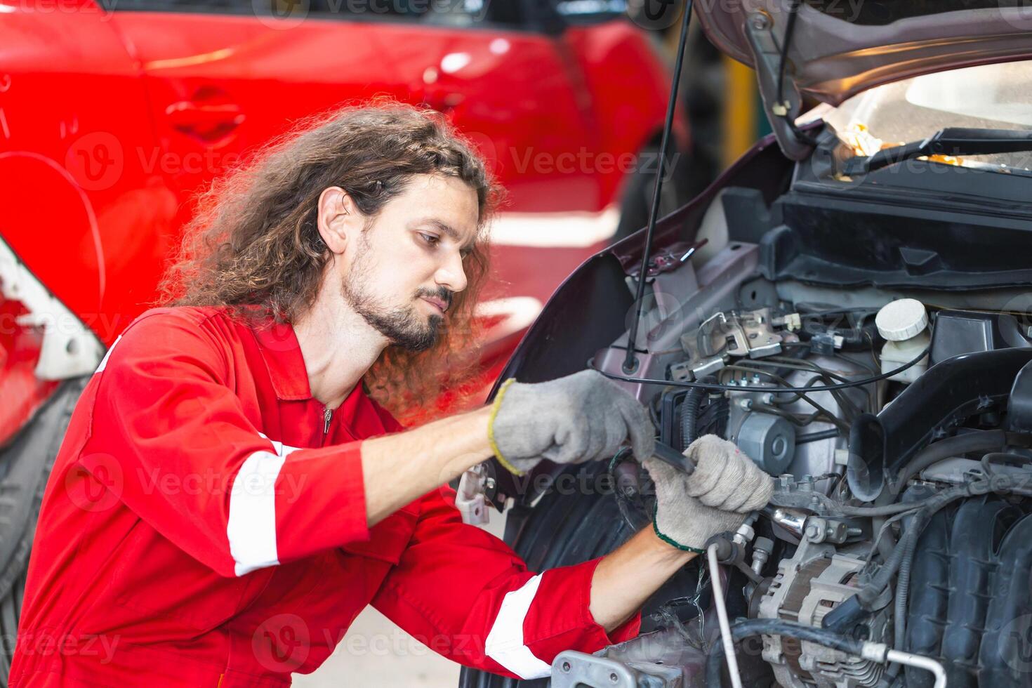 Mechanical man working in garage, Young mechanic fixing car in auto repair shop photo