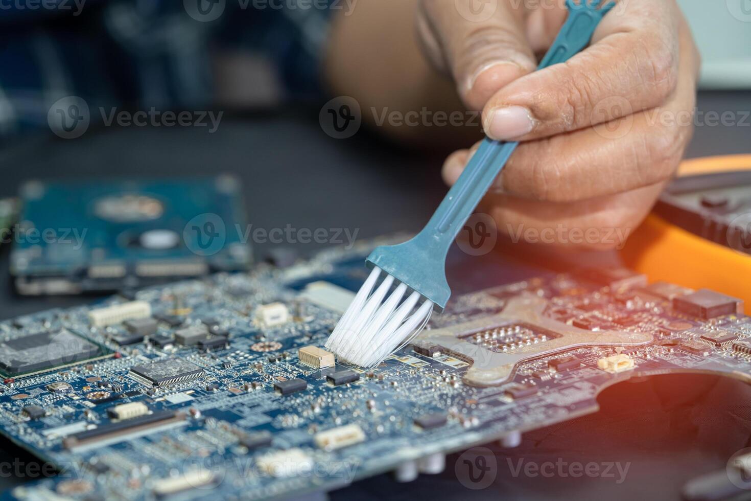 Asian technician repair and cleaning dirty micro circuit main board of smartphone electronic technology with brush, hardware, mobile phone, upgrade concept. photo