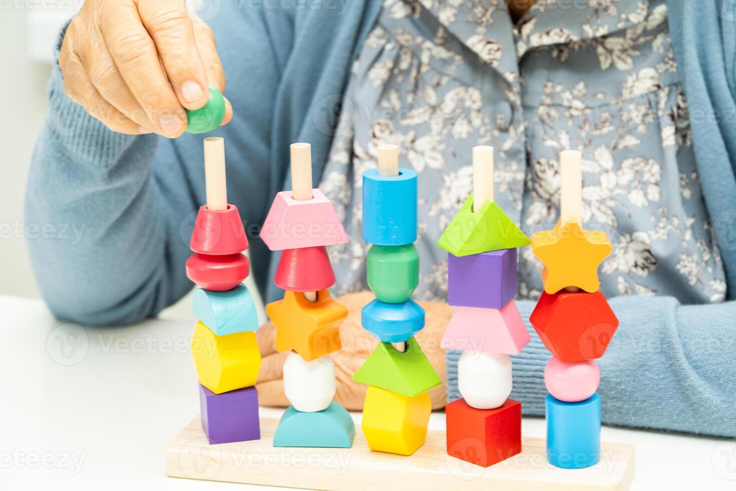 Alzheimer disease AD, Asian elderly woman patient suffering from dementia learn practical motor skills rehabilitation. photo