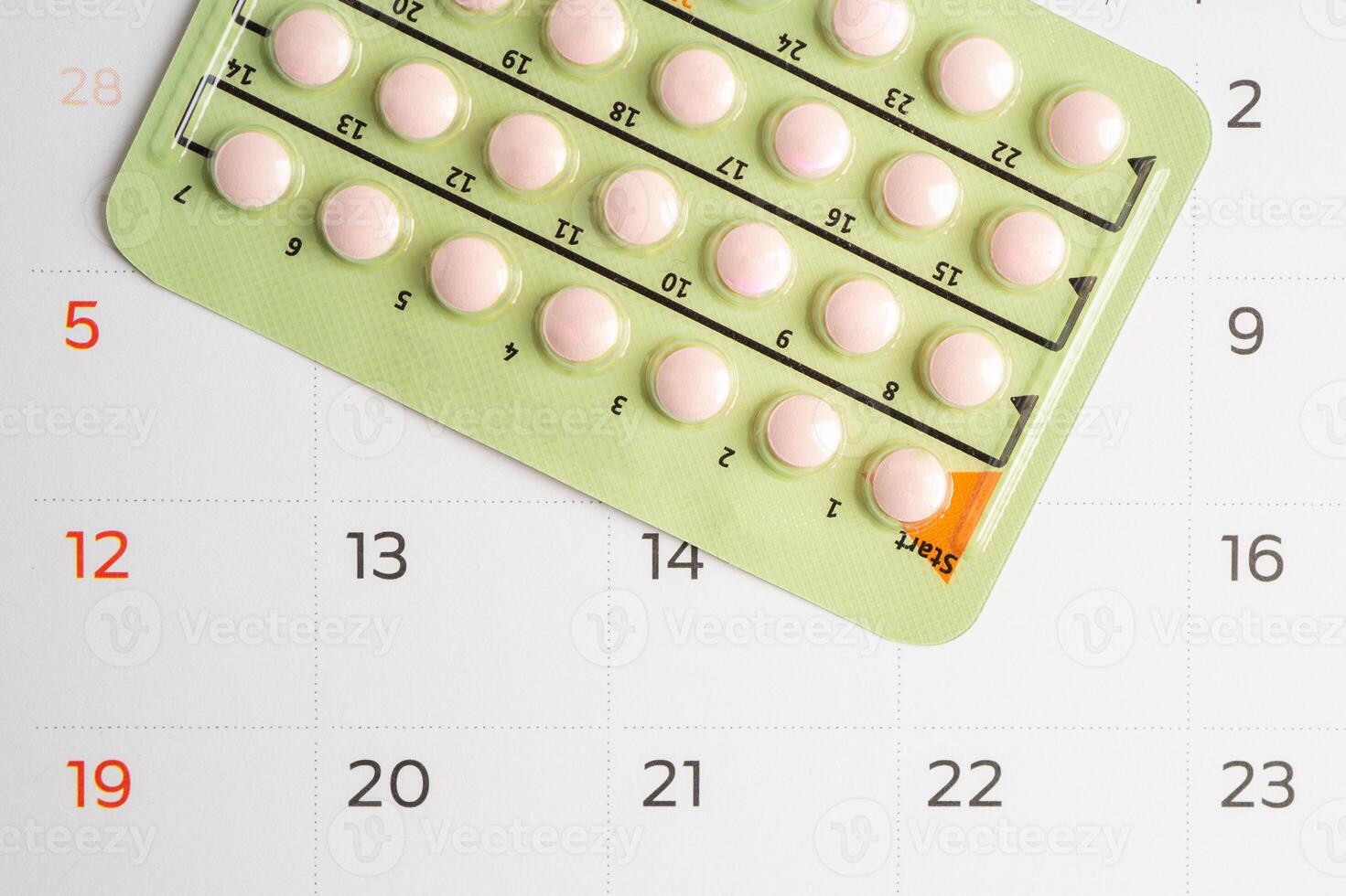 Pregnancy test and birth control pills on calendar, contraception health and medicine. photo