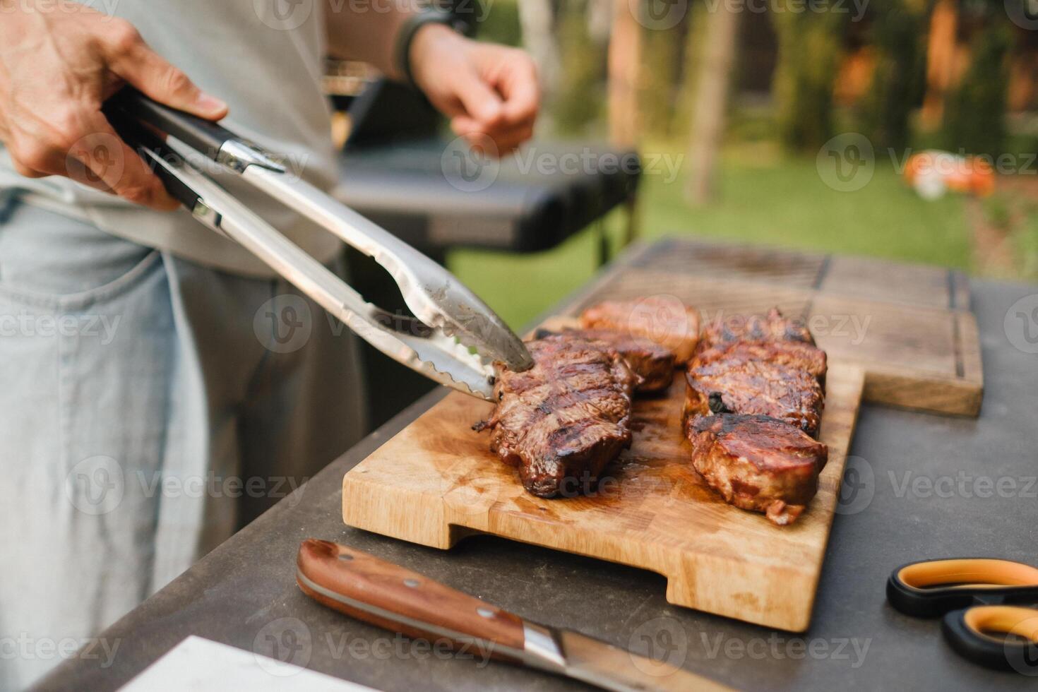 un hombre en el calle cocido un filete en el parrilla en un parilla foto