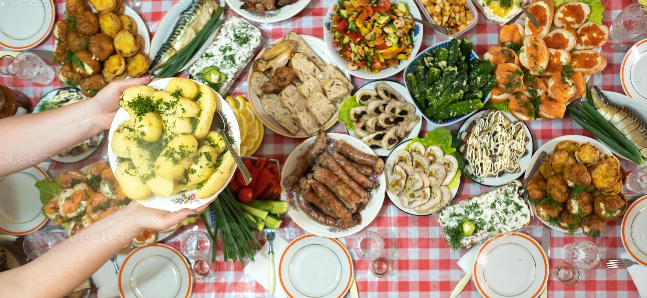 un lote de diferente comida en el banquete mesa y servido hervido patatas con eneldo.a grande número de confeccionado platos en el mesa.vacaciones a el mesa foto