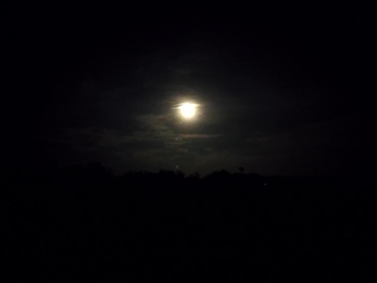 the moon is shining brightly in the dark sky photo