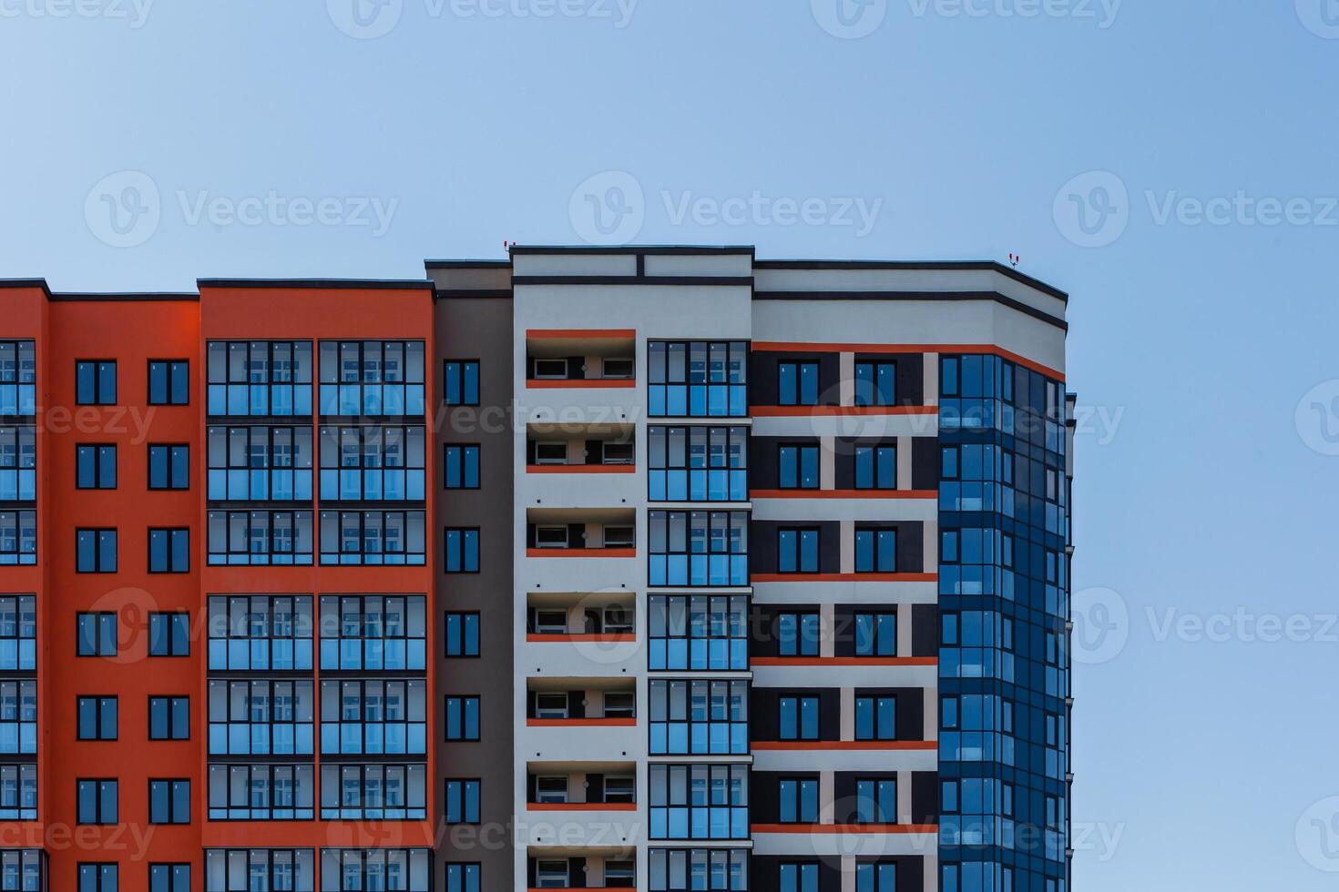 new high rise apartament building with multiple balcony and windows on blue sky with white clouds background photo