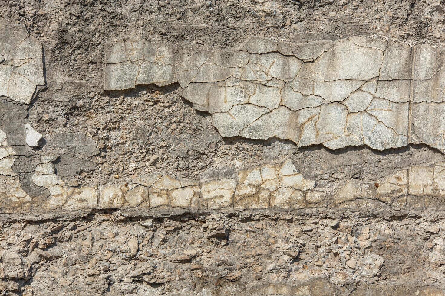 cracked white concrete wall under direct sun light full frame background and texture photo