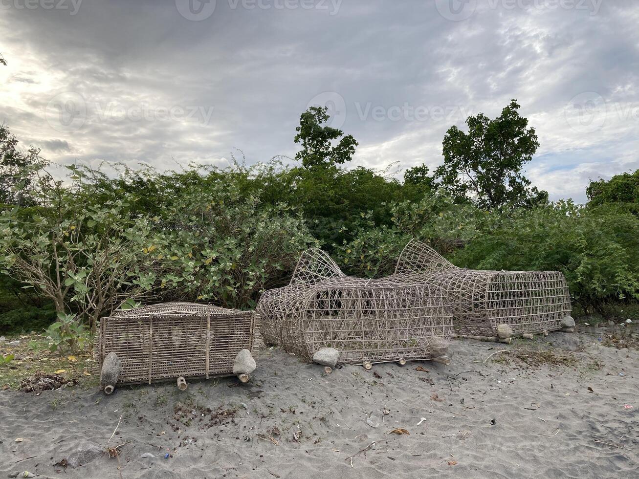 Trap for crab fish lobster lobsters cages braided from bamboo lie on a sandy shore photo