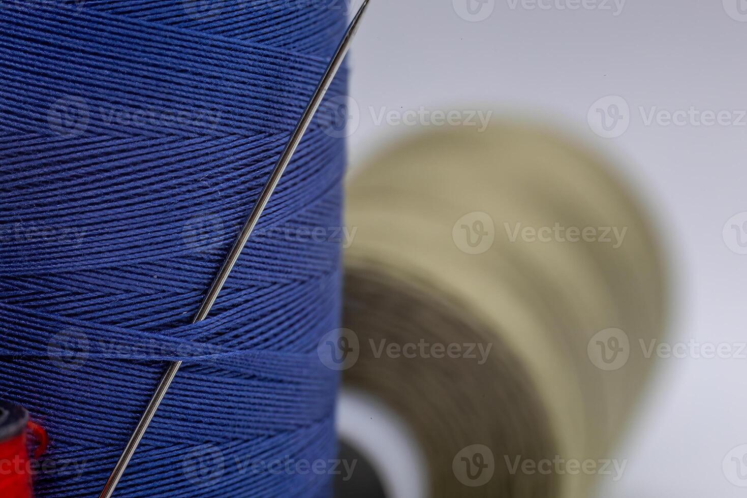 Detailed close-up shot of a needle in a blue thread photo
