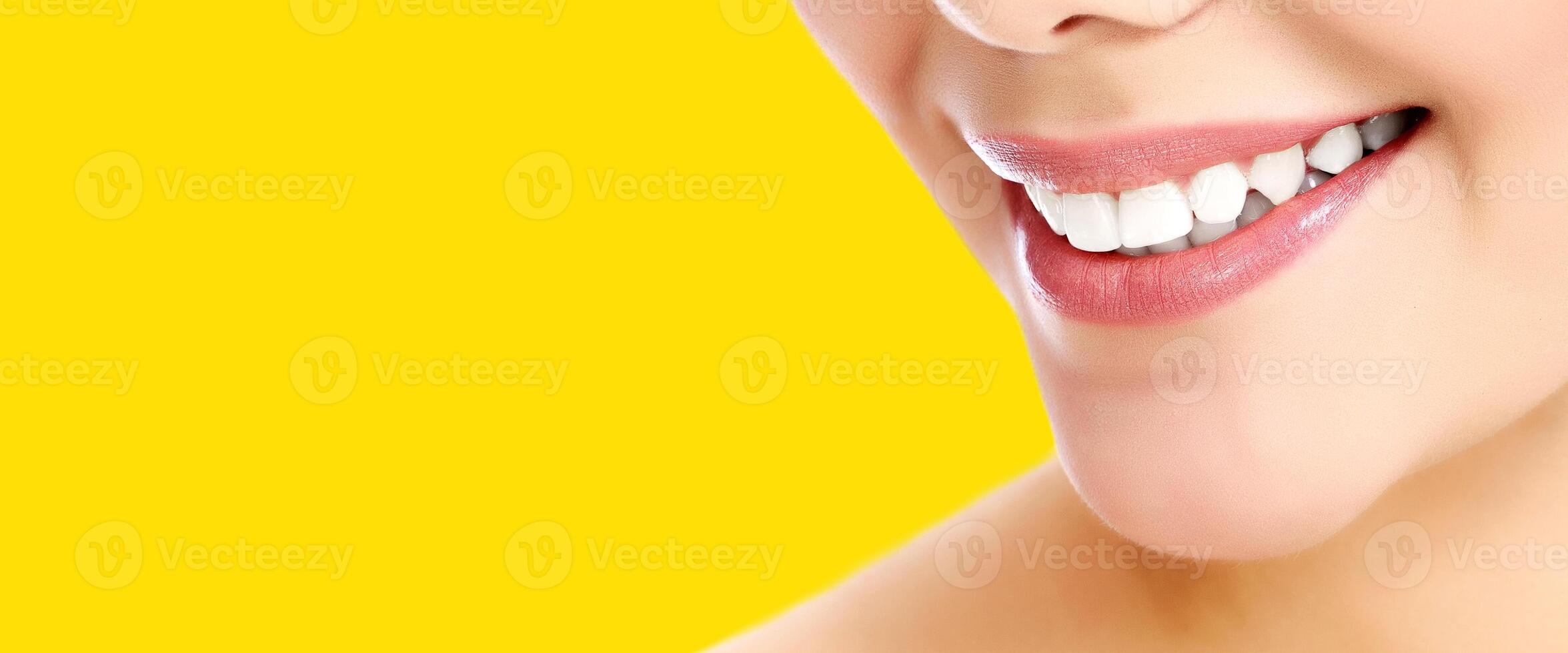 Pretty woman smiling against a yellow background with copyspace photo