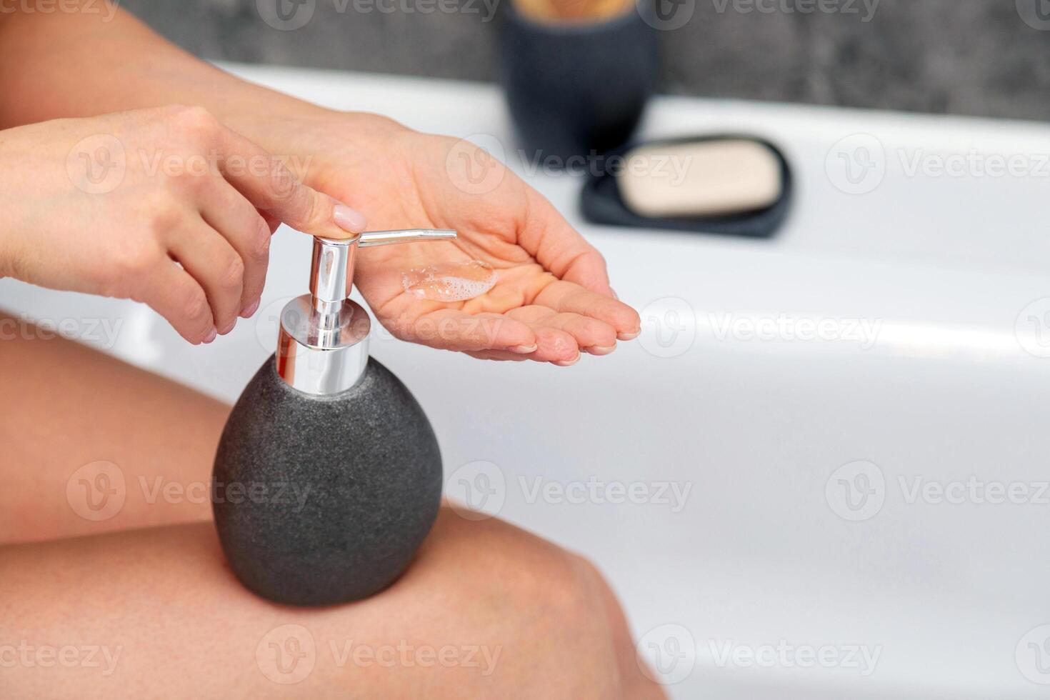 Closeup of woman washing hands with soap in bathroom at home photo