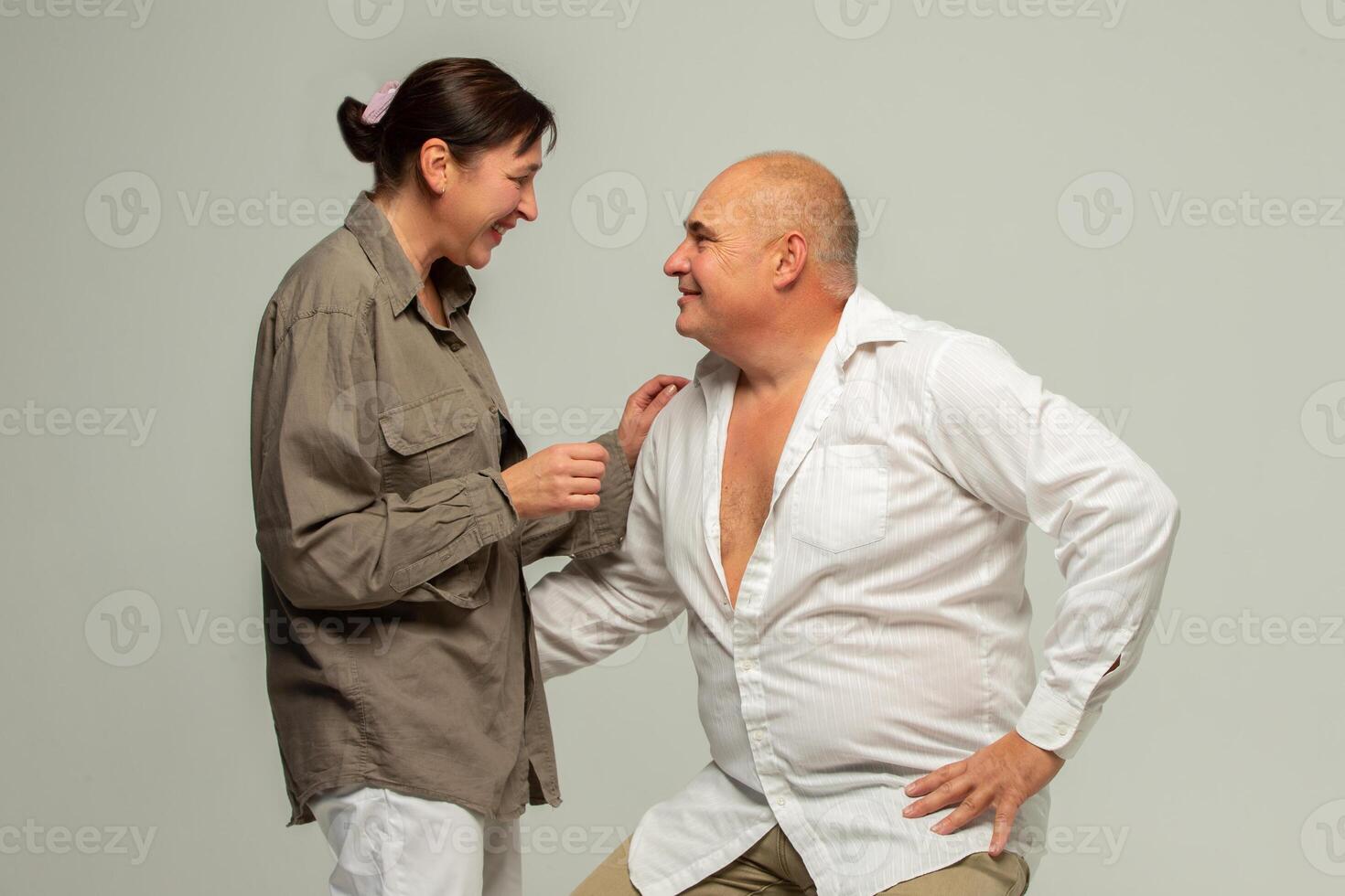 Portrait of a mature couple. Cheerful laughing funny couple, two friends, elderly gray-haired brunette man in casual clothes standing, hugging and communicating photo