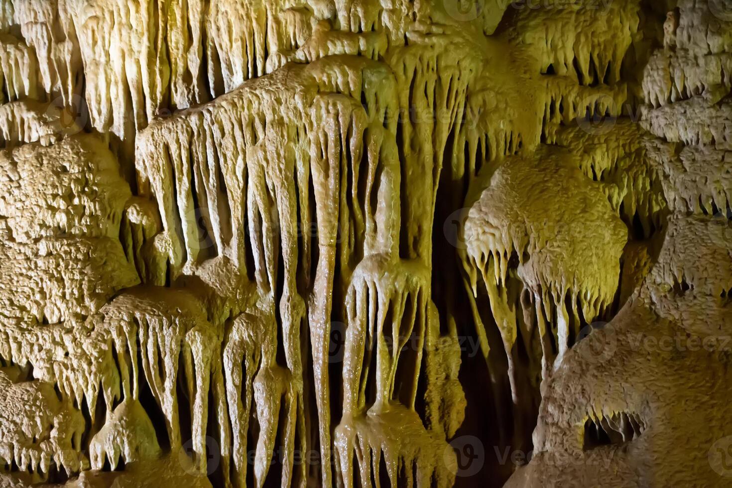 el cueva es karst, increíble ver de estalactitas y estalagnitas iluminado por brillante luz, un hermosa natural atracción en un turista lugar. foto