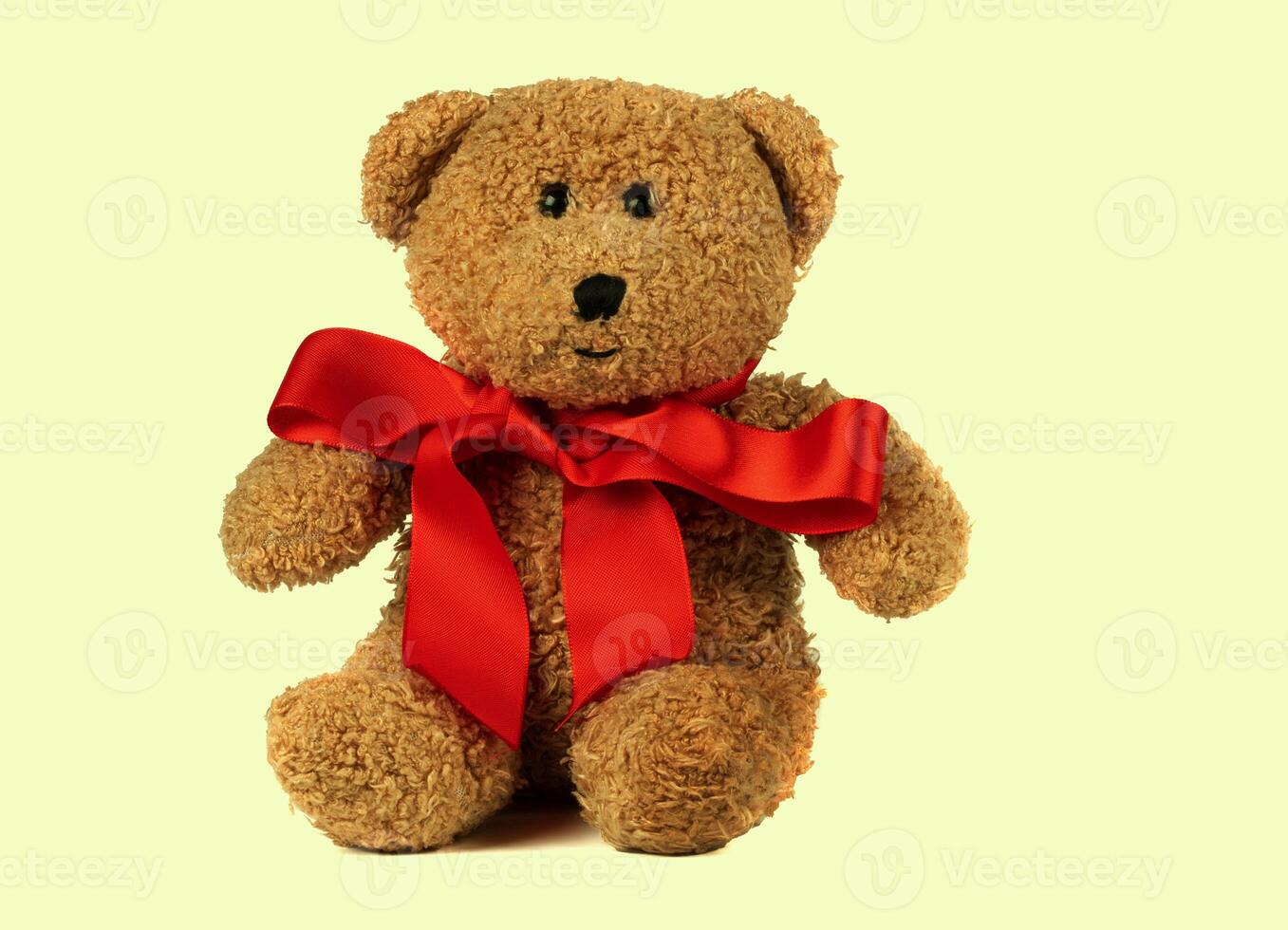 Toy fluffy vintage bear with a red bow on a retro background. Children's cute soft toy. photo